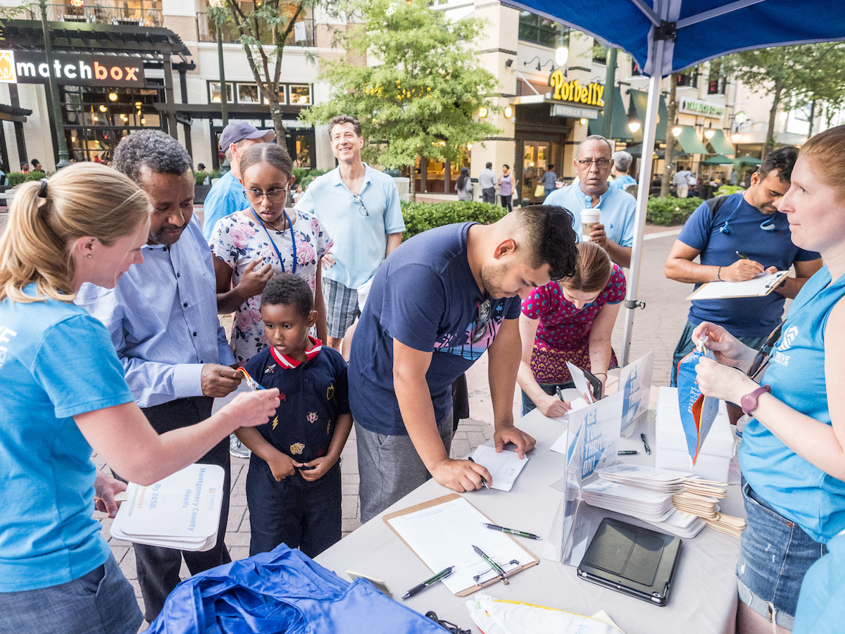 Community members at Thrive Montgomery tent Ellsworth Fountain Plaza Stage 