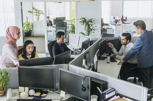 Busy office with men and women working at desks