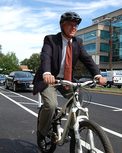 Casey Anderson cycling in a bike lane