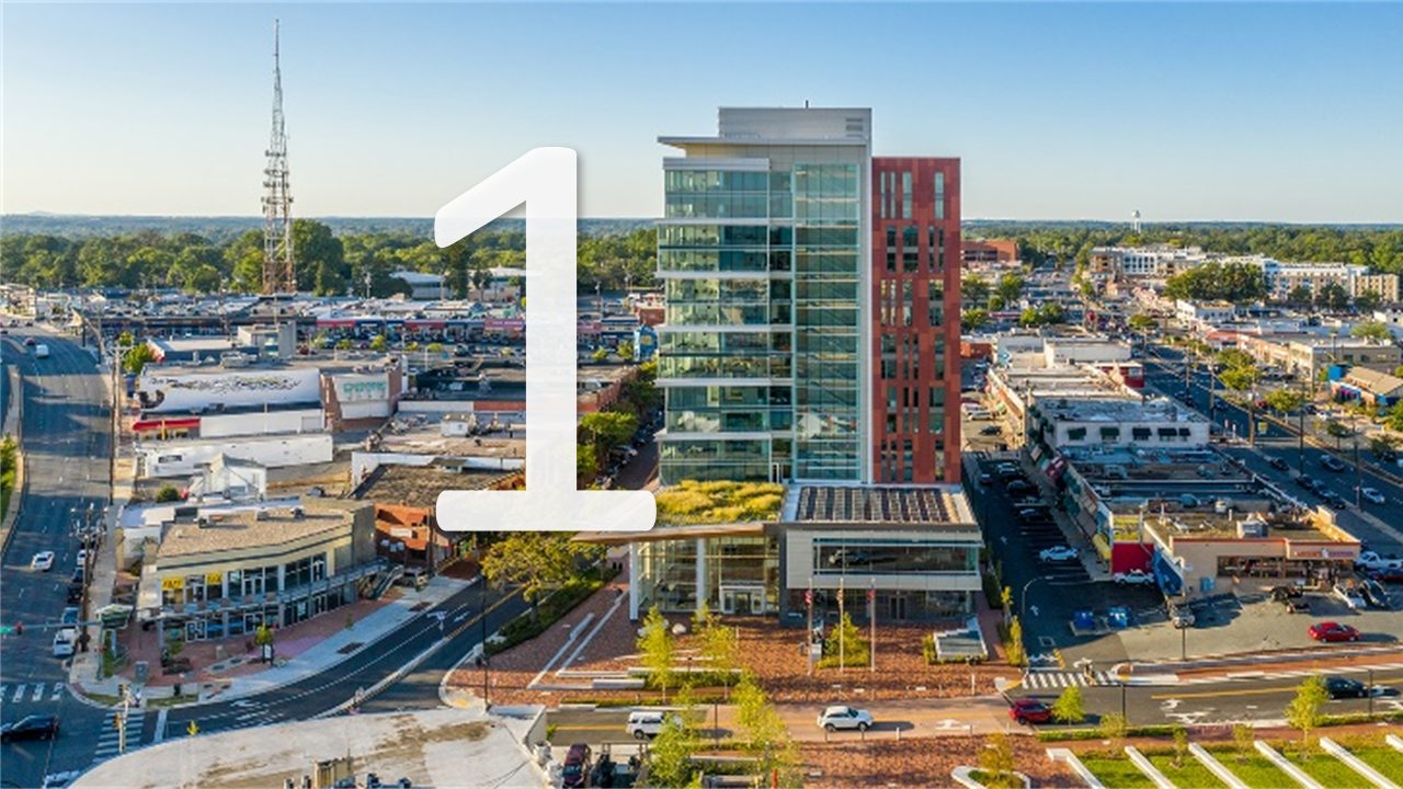 an aerial shot of the M-NCPPC Headquarters towering over the urban area of downtown Wheaton with a number one in front of the picture.