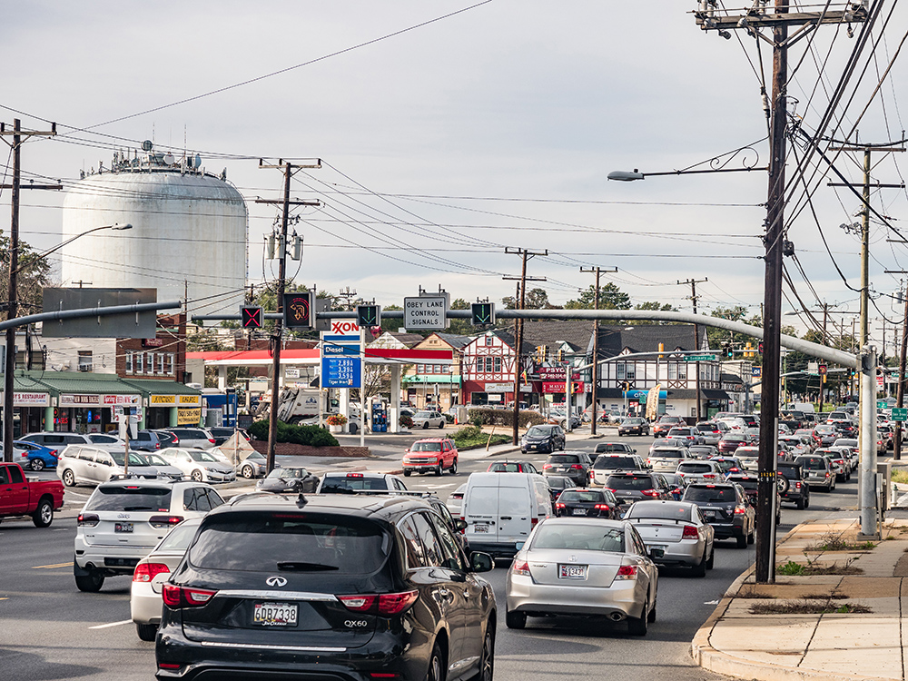congestion and traffic on Georgia Avenue looking north in Forest Glen/Montgomery Hills. Shows a water tower in the background with lanes of traffic in the foreground along with retail
