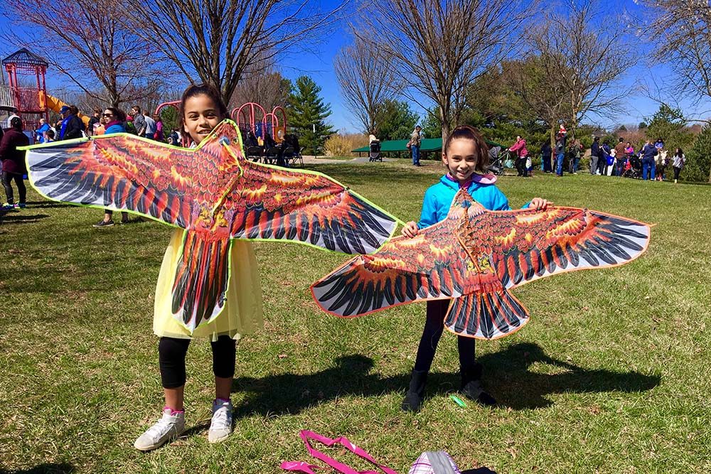 two children holding bird kites