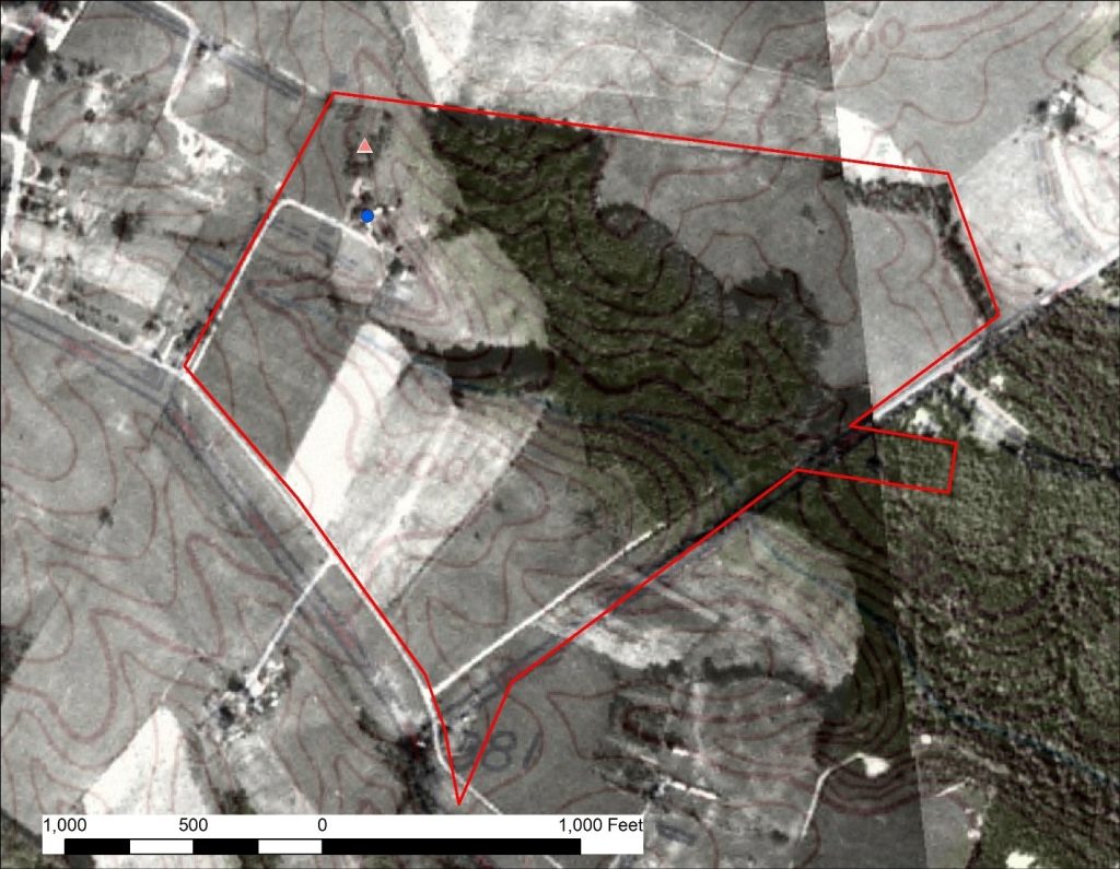Black and white aerial photograph with historic farm boundary shown as a red line, topographic lines in brown, a blue dot for the location of the original family house, and a red triangle in an area of trees north of the house indicating a possible location for the burial ground. A scale bar shows distance indicating that the possible cemetery location is less than 500 feet from the house.
