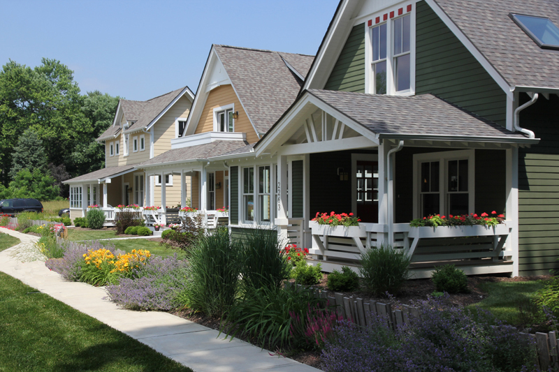 photo of three homes that are small bungalows in Carmel, IN showing porches and a common courtyard. The photo is meant to convey how this type of housing could fit seamlessly into an existing residential neighborhood.
