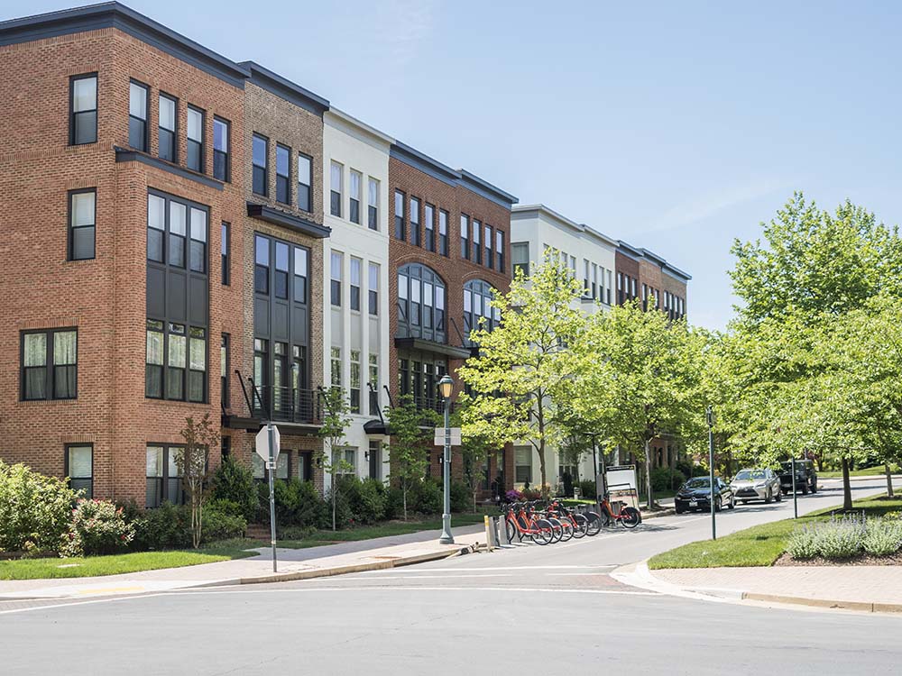 Townhome with bikeshare stations in front on treelined street