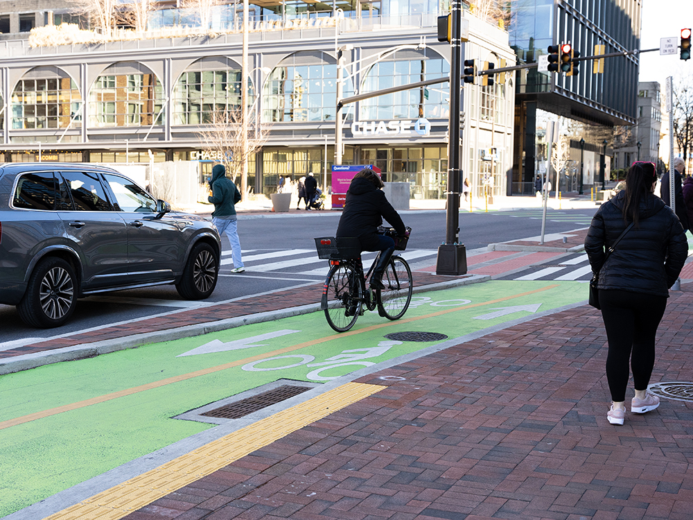 cyclist rides in separated bike lane painted green