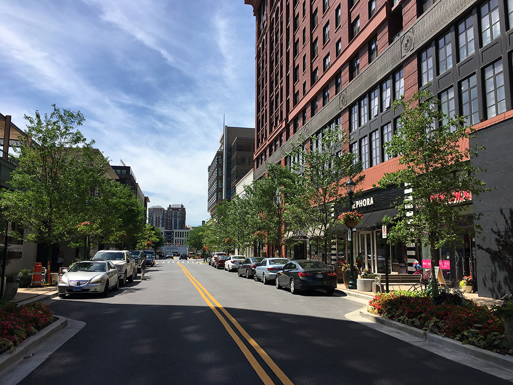 Tree lined street with street parking and storefronts