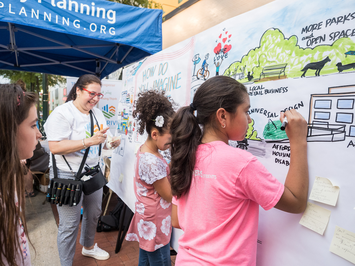 Kids drawing on a canvas board at a community event hosted by Montgomery Planning.