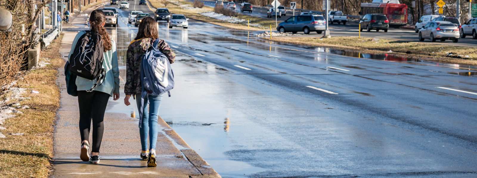 Pedestrians on sidewalk by a mulitlane road