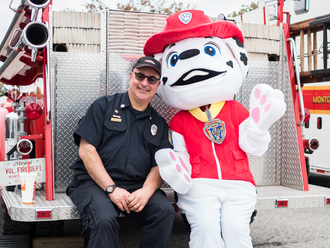 Fireman and dog mascot on back of firetruck