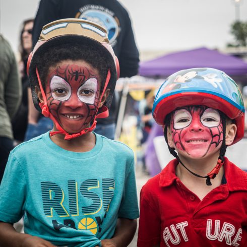 Two children with painted faces wearing bike helmets at Martial arts demonstration at Burtonsville Placemaking Festival