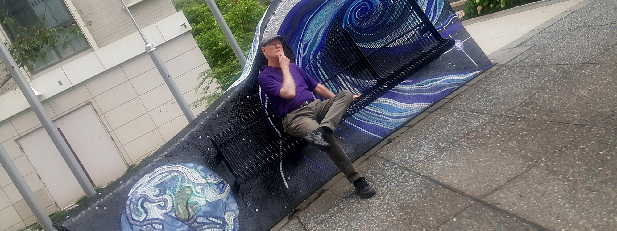 Man sitting on bench by art in Silver Spring