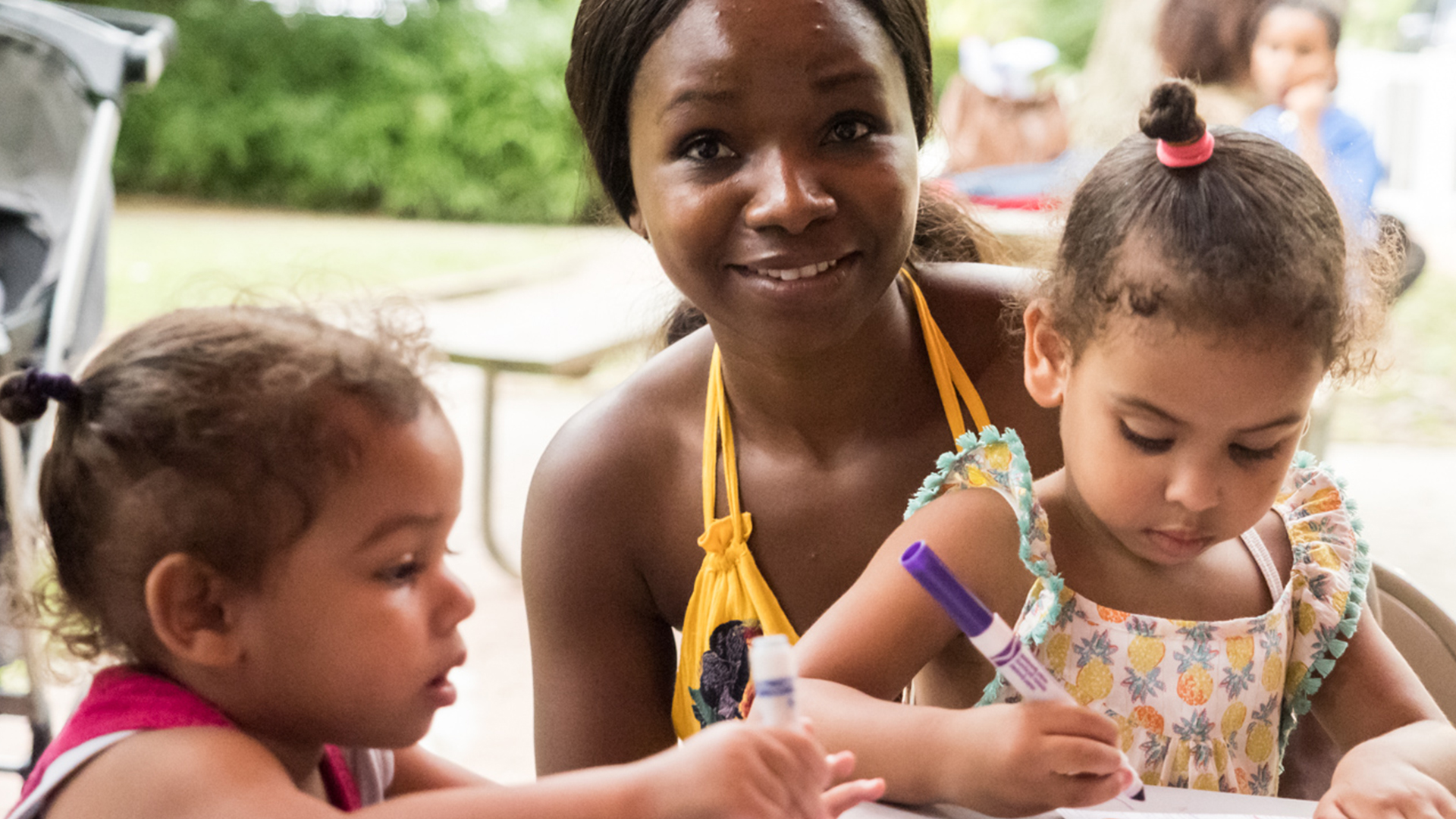 woman and two small children engaged in art activity at Thrive Week event