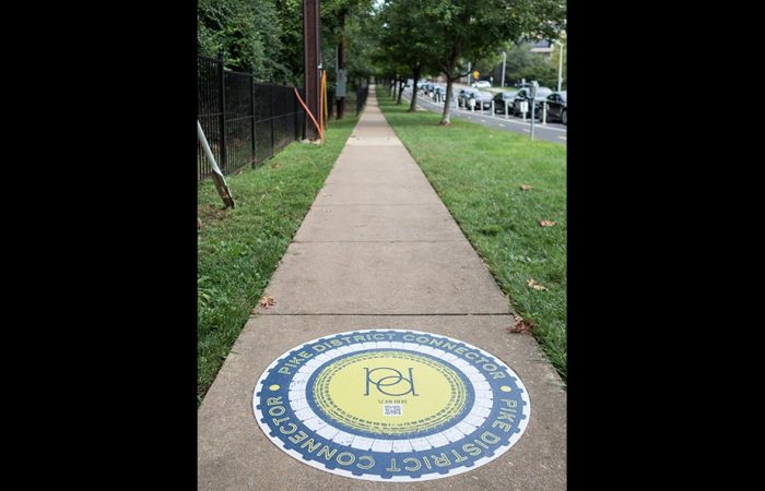 Pike District Connector launch event Pike District connector logo on sidewalk