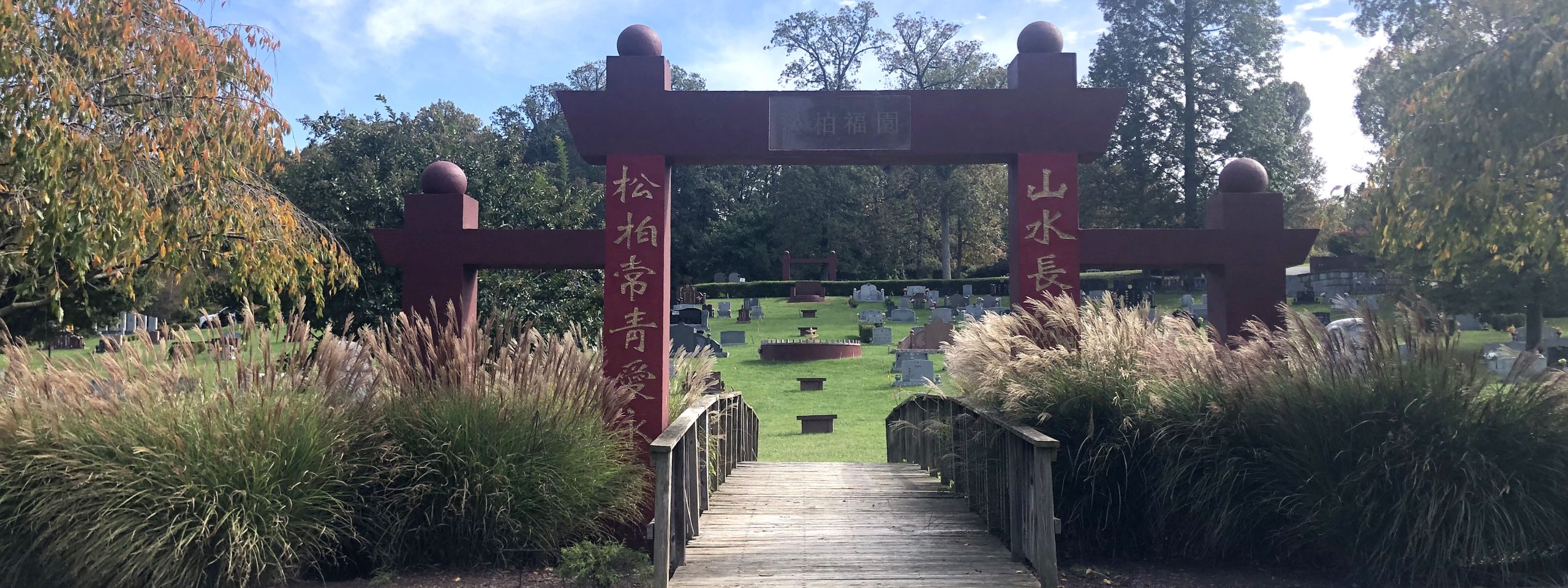 A cemetery entrance marked by a gate with Chinese text
