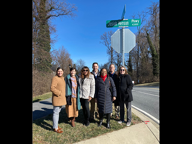 Montgomery Planning staff by stop sign with new Josiah Henson Parkway street sign