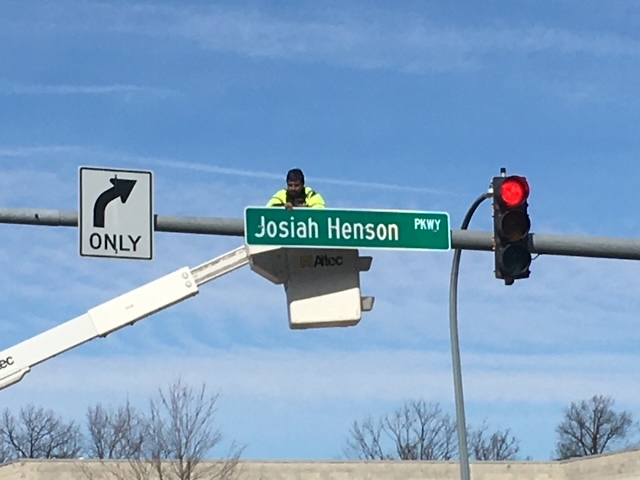 Worker installs new Josiah Henson Parkway sign by traffic light