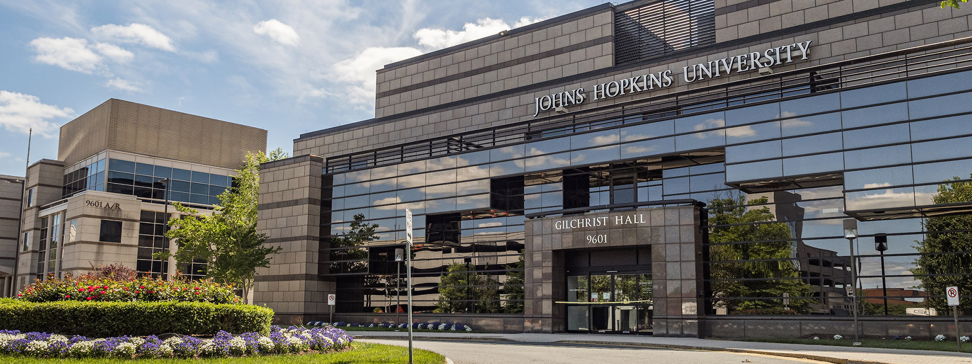 Johns Hopkins University Gilchrist Hall. Gray brick building with glass front