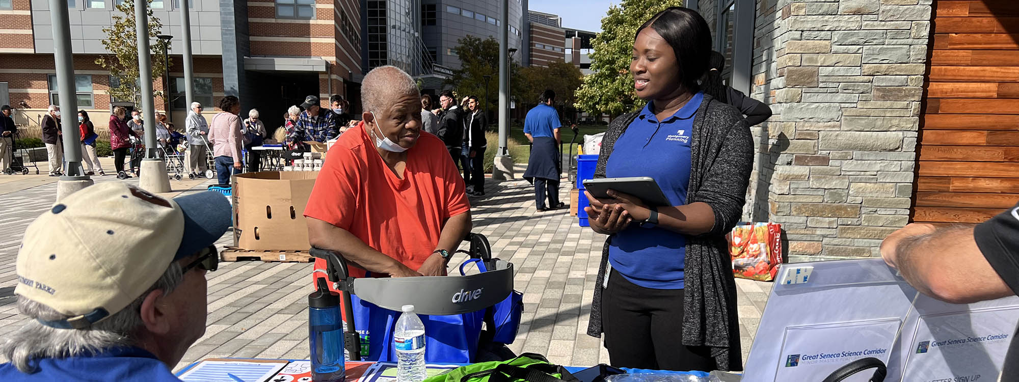 Montgomery Planning staff member talks with community member using a walker at outreach event