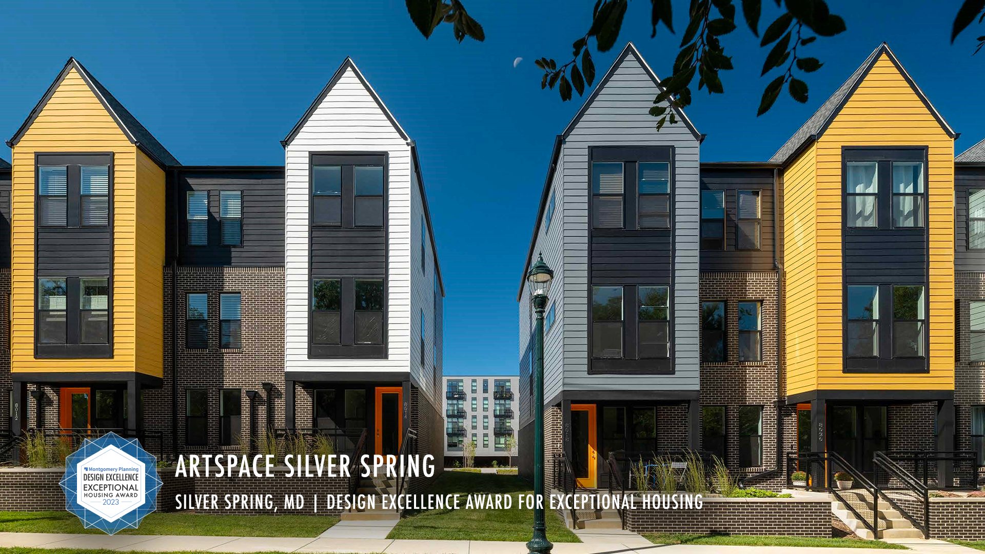 Artspace Silver Spring. four gray brick town homes each with yellow, white of gray siding on portion of structure