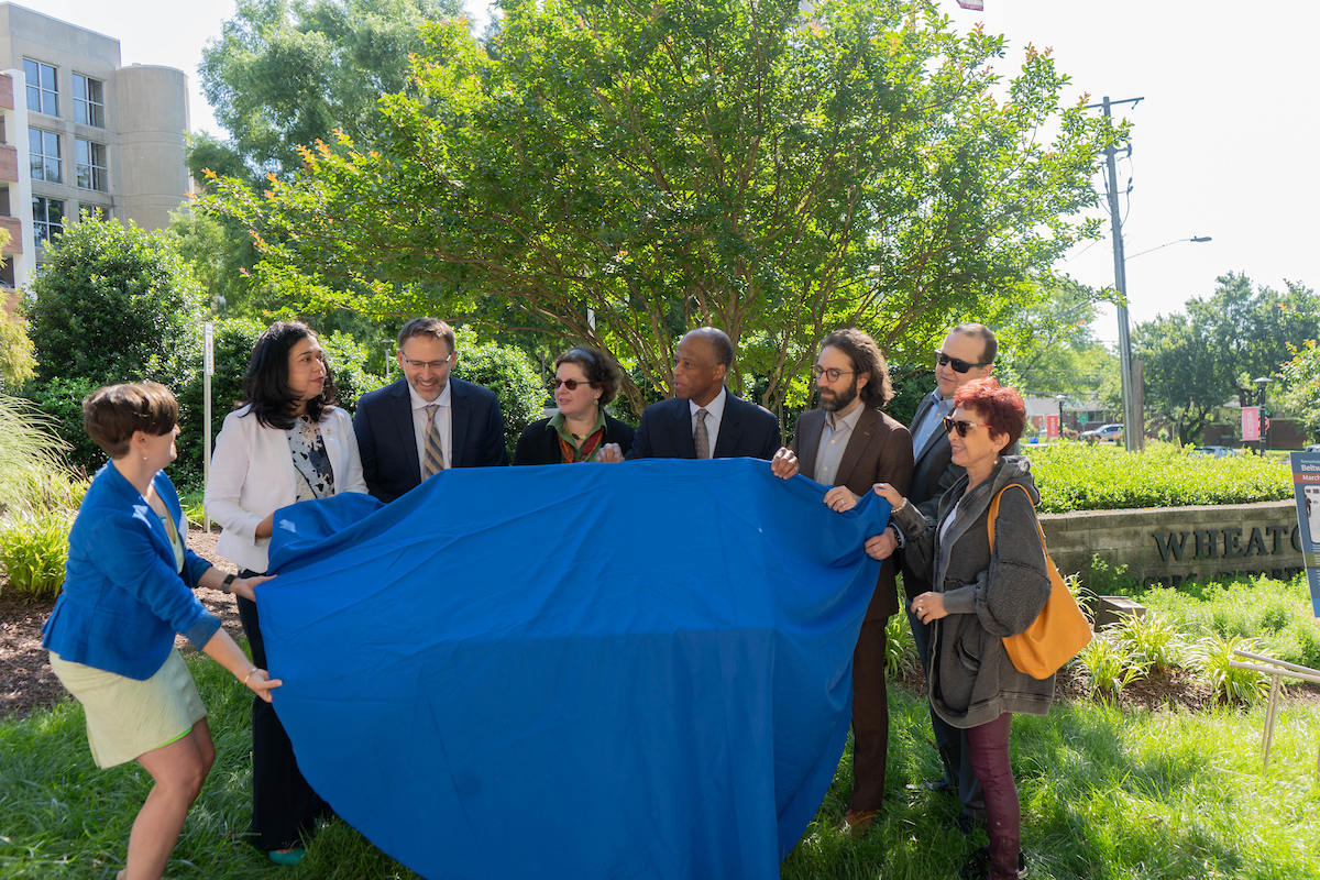 Group about to unveir marker covered by blue cloth