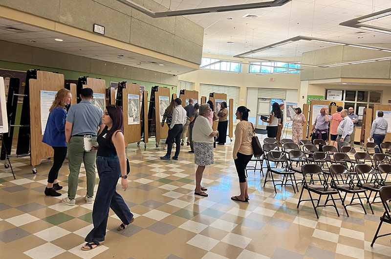 community members explorer poster stations in cafeteria