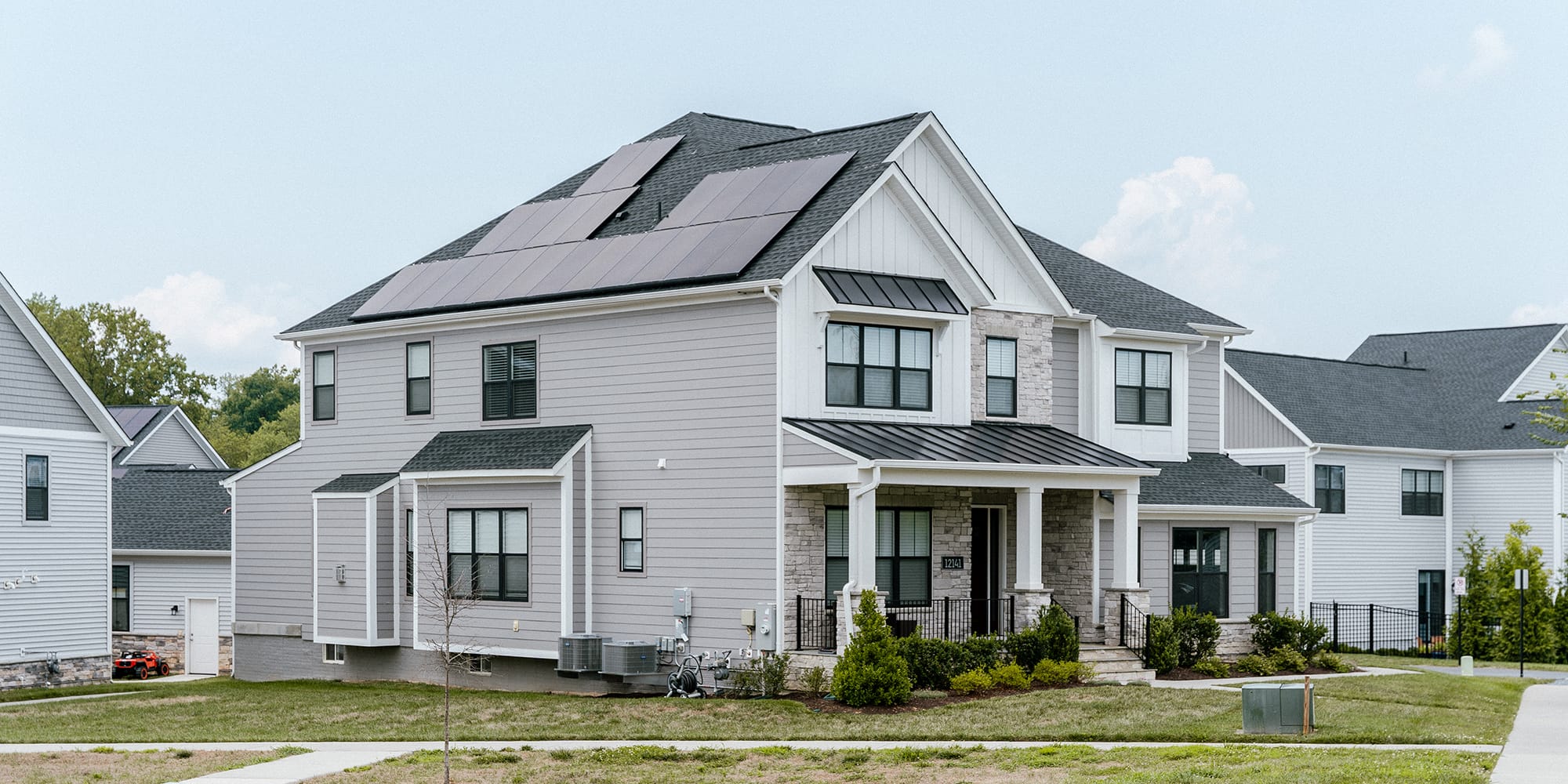 white two-story house with solar panels on roof