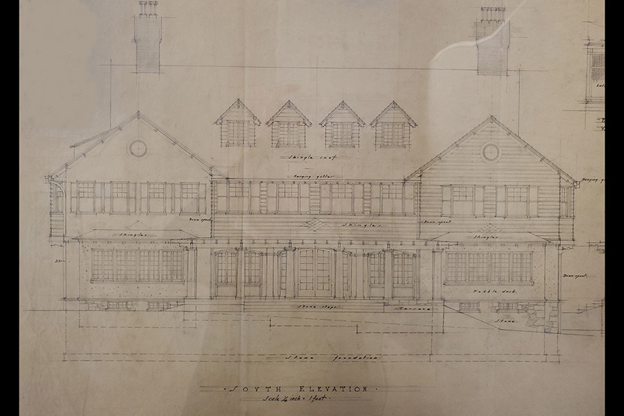 Architectural blueprint of a building labeled "South Elevation." The design includes detailed drawings of the structure, three dormer windows on the roof, and a covered porch. Various architectural notes and measurements are visible.