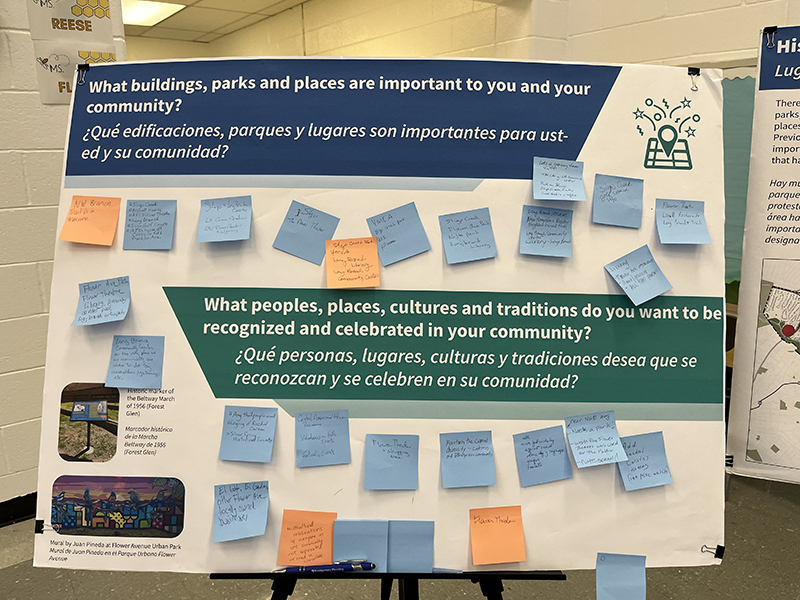 A board with questions about important community places and cultures, covered in various blue and orange sticky notes with responses.