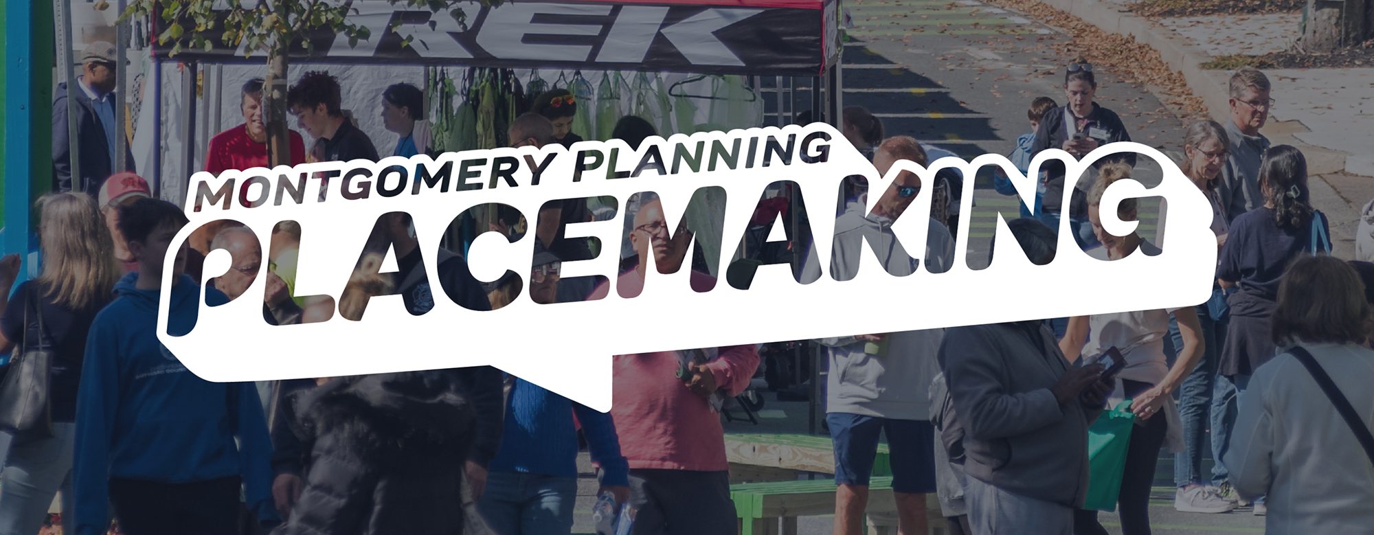 A crowd of people gathers outdoors under a tent with the text "Montgomery Planning Placemaking" prominently displayed in the foreground.